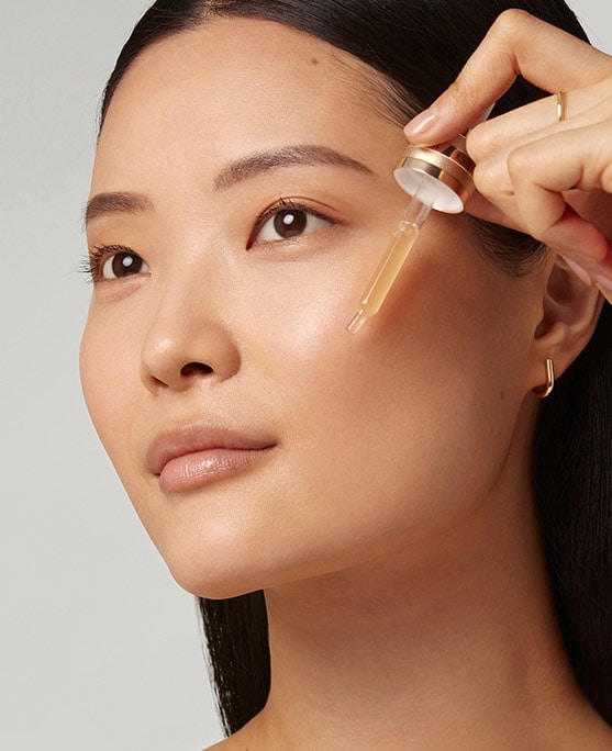 Photo of woman applying Advanced Night Repair Serum in skin cycling routine