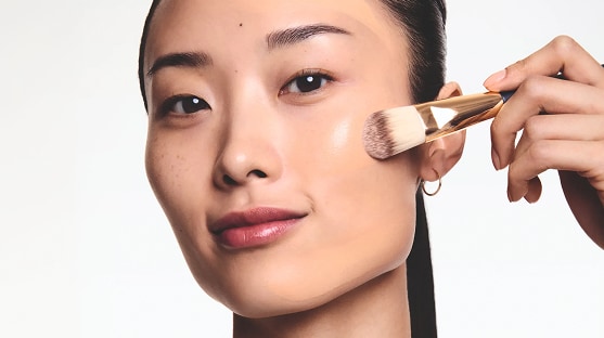 woman applying long lasting makeup from estee lauder