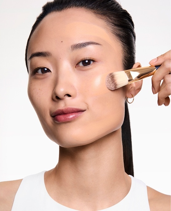 woman applying long lasting makeup from estee lauder