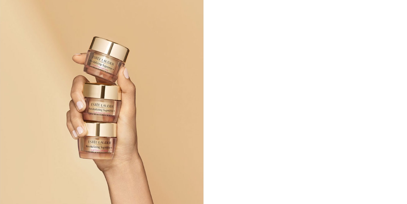 Hand holding three travel size cream containers