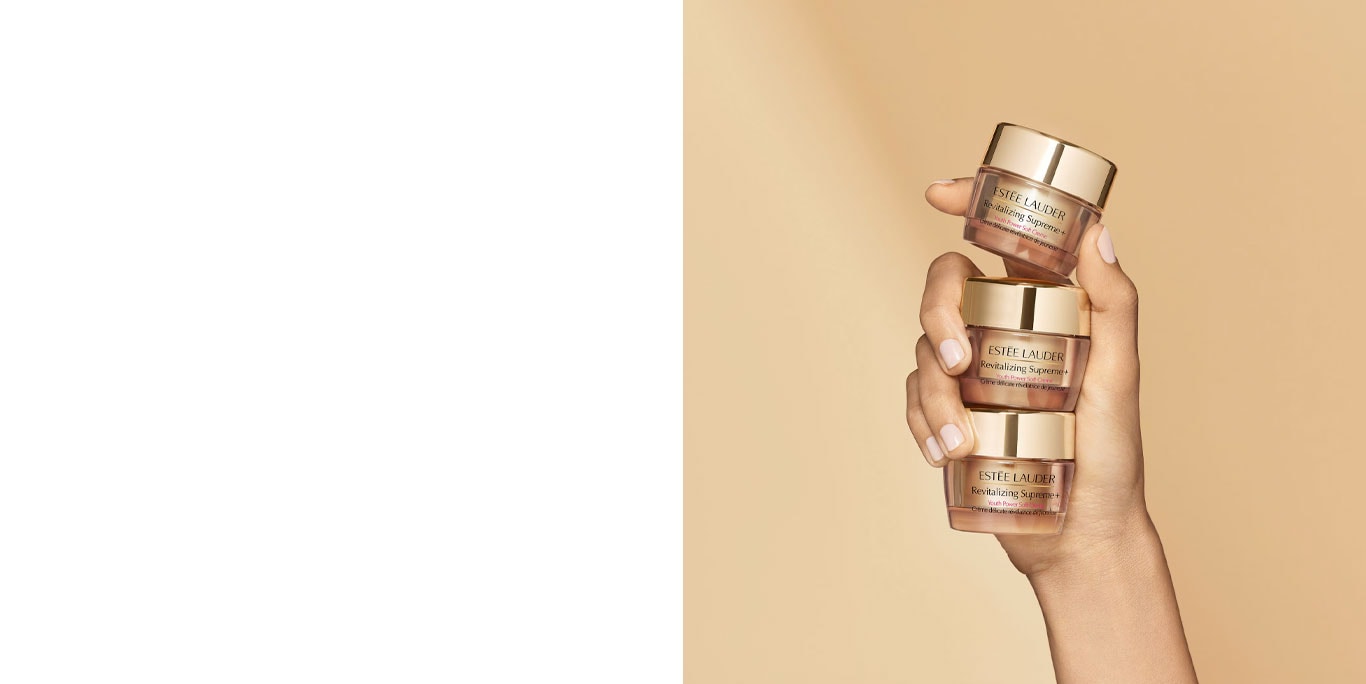 Hand holding three travel size cream containers